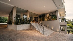 A modern building with a staircase, glass doors, and potted plants. - Onrock Boutique Hotel (Ella)