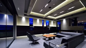 A modern lounge area with a sofa, a table, and a chair.