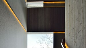 A modern staircase with a view of bare trees and a clear sky.