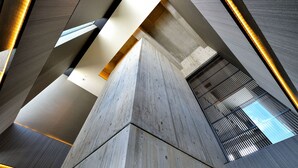 A modern architectural structure with concrete pillars and a sloped ceiling.