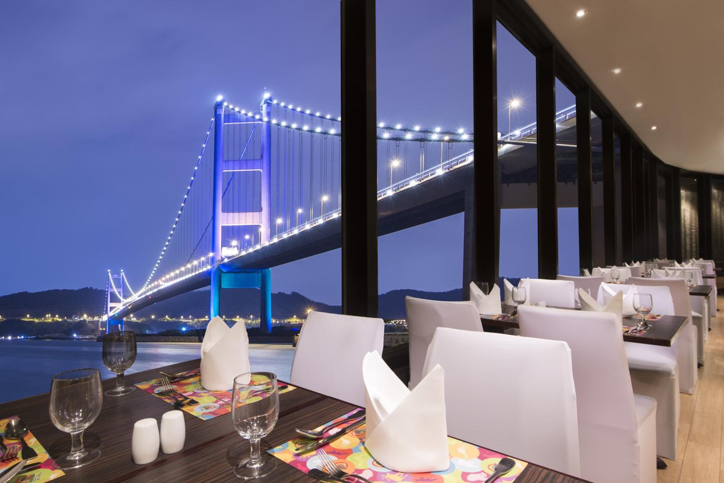 A dining area with a view of a bridge at night.