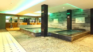 Un área de spa con dos jacuzzis, un mostrador de recepción y una zona de estar.