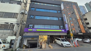 Un immeuble à plusieurs étages, sur lequel on peut voir une grande enseigne indiquant « HÔTEL BUSAN VIEW ».