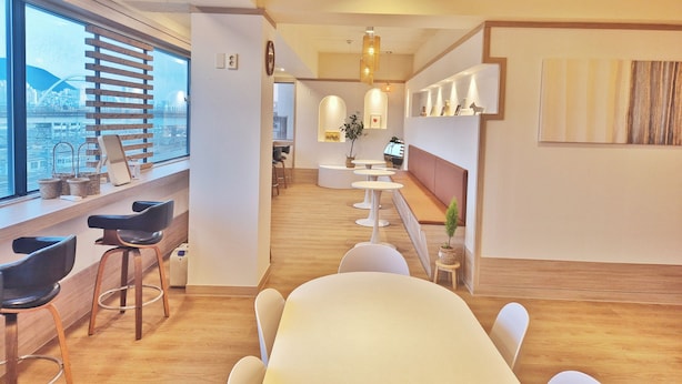 Un intérieur moderne avec une longue table à manger, un bar et un espace salon.