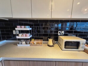 Full-sized fridge, microwave, coffee grinder, cookware/dishes/utensils