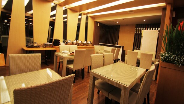 A restaurant with a modern interior, featuring wicker furniture and a warm color scheme. - The L Hotel Entertainment (Batam)