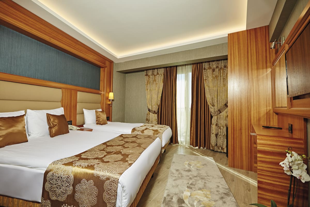 A hotel room with a large bed, a desk, and a mirror.
