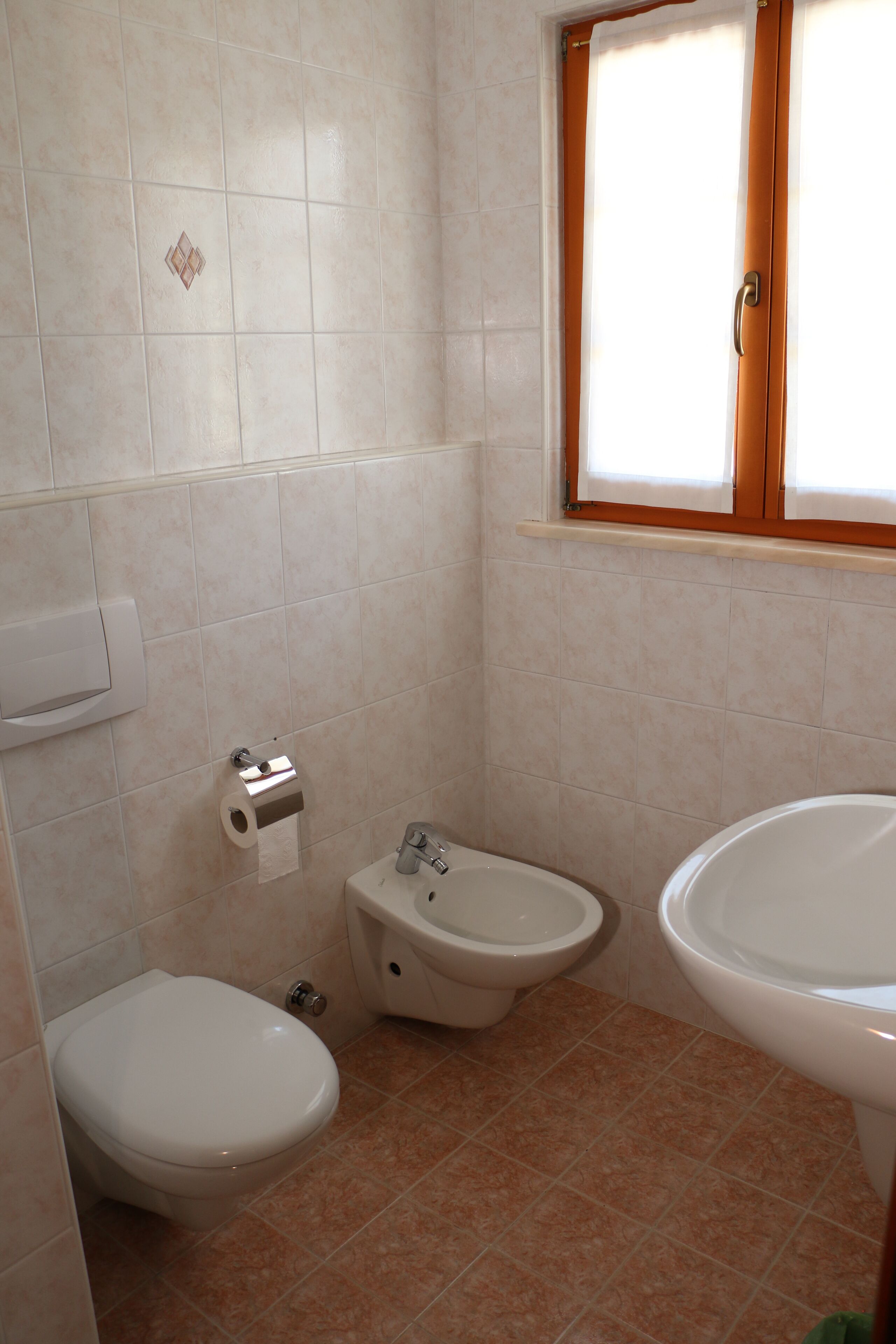 Un bany petit amb vàter, bidet i rentapel.