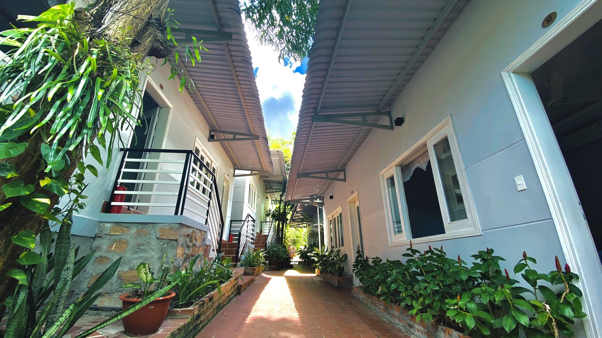 A narrow pathway flanked by buildings with a covered walkway overhead.