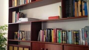Una estantería con varias repisas llenas de libros.