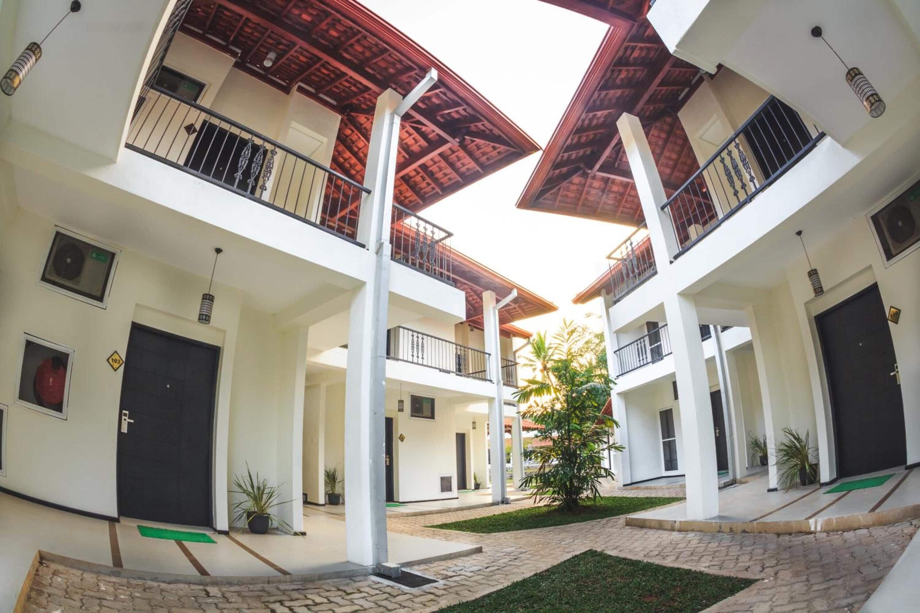 A multi-level building with balconies, a central courtyard, and a staircase.