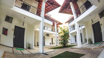 A multi-level building with balconies, a central courtyard, and a staircase.