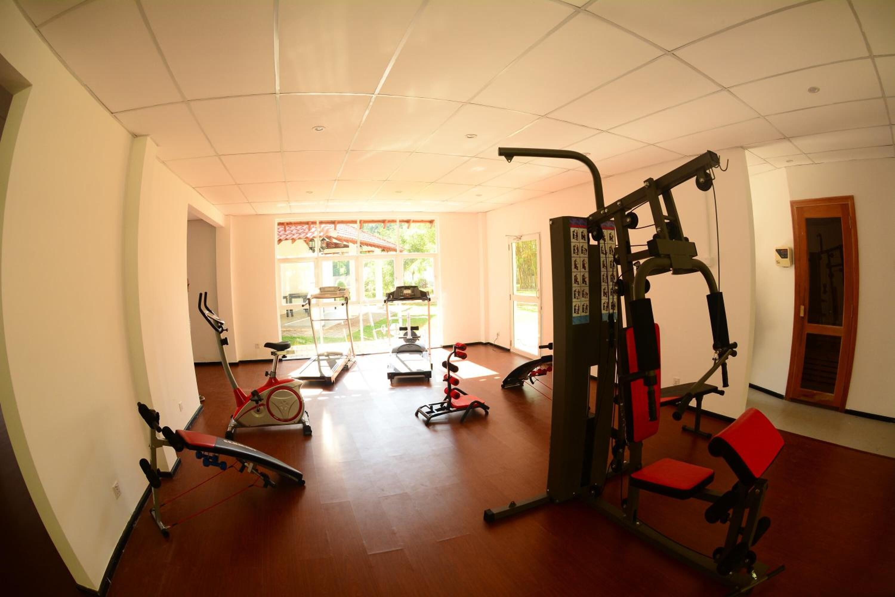 A gym with exercise equipment, a treadmill, and a stationary bike.