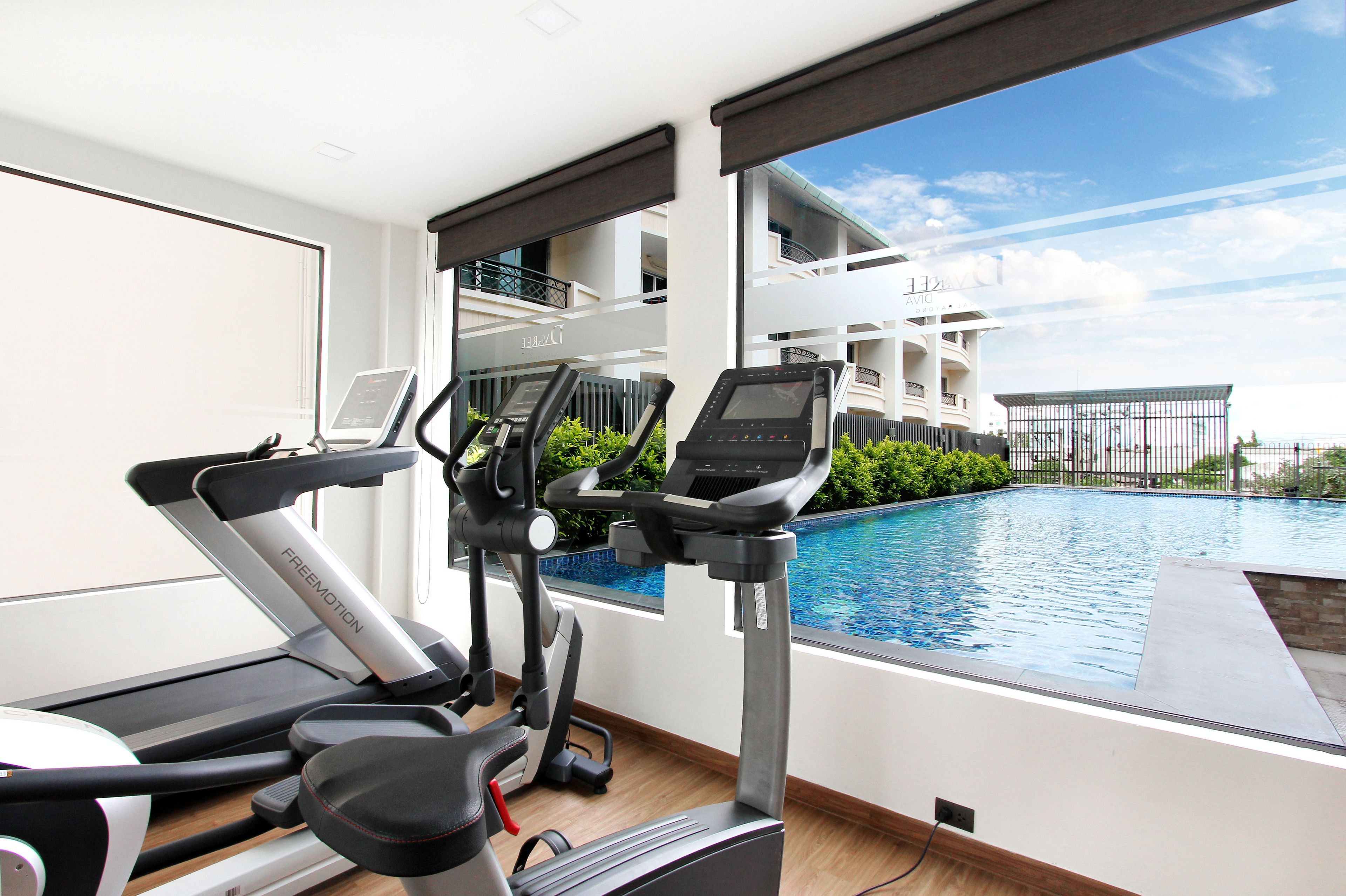 A fitness area with treadmills and a pool view.
