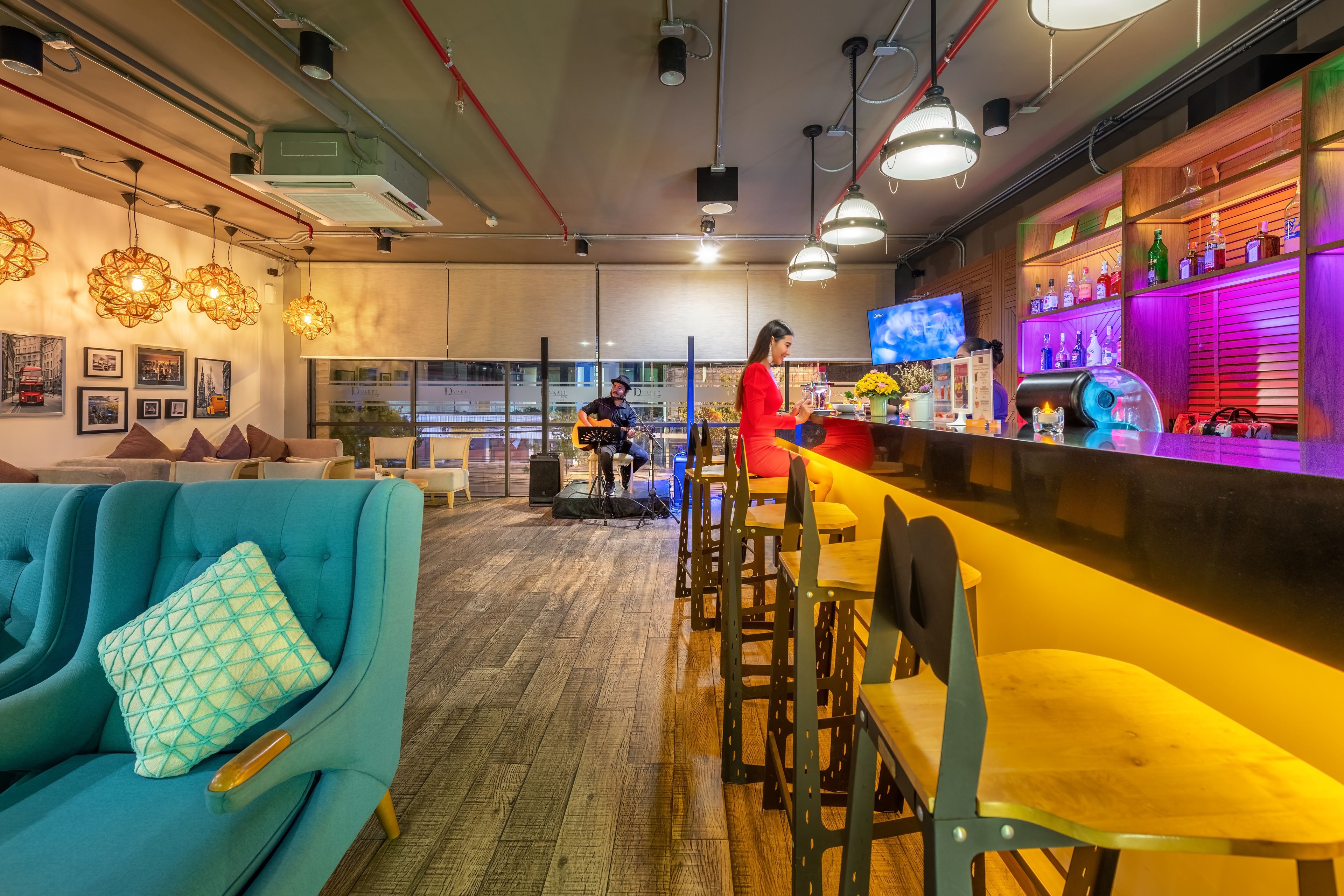 A bar area with a counter, bar stools, and a television screen.