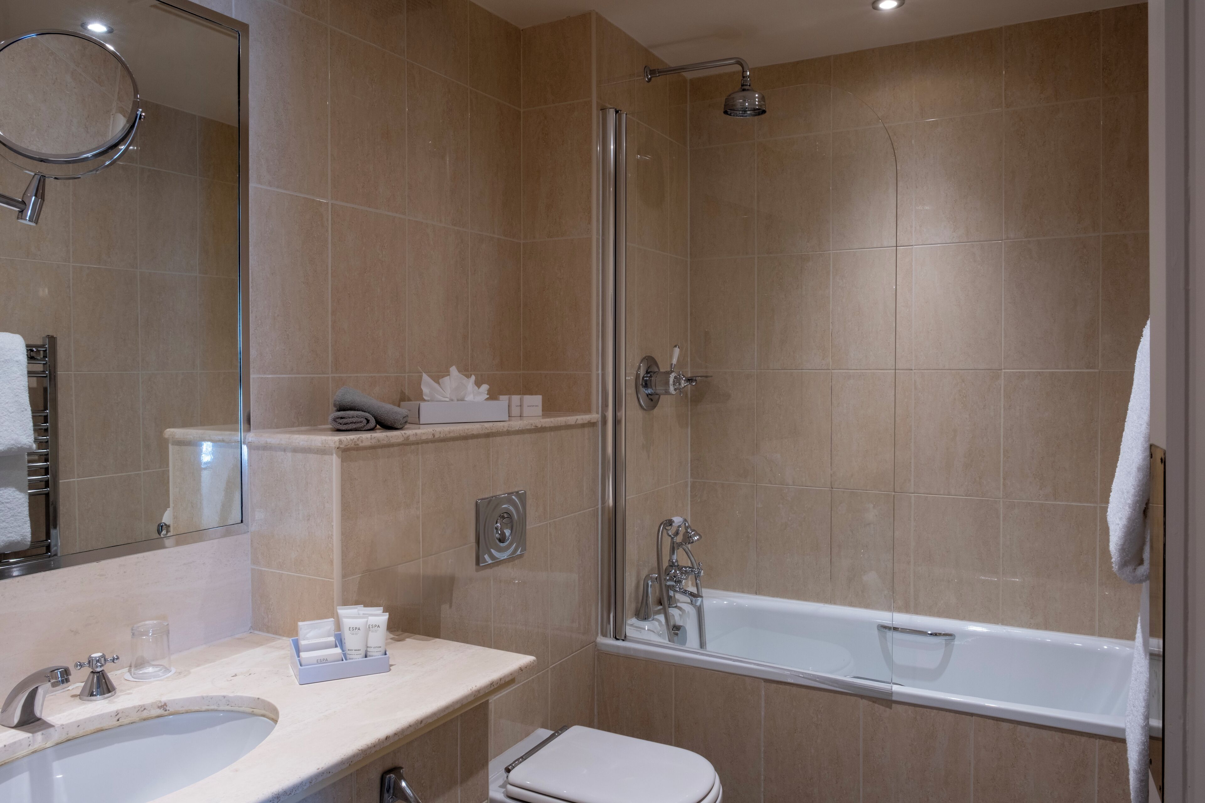 A modern bathroom with a sink, toilet, and bathtub.