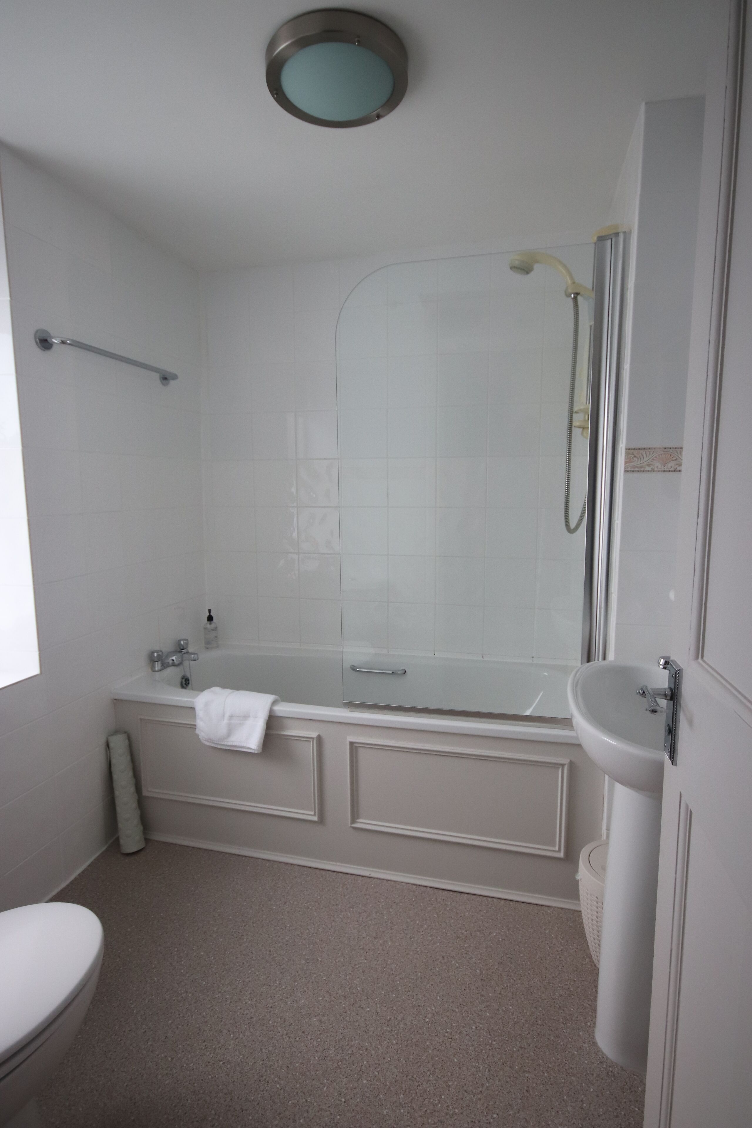 Ein modernes Badezimmer mit Badewanne, Dusche und Waschbecken.