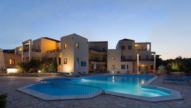A hotel with a swimming pool, multiple balconies, and stone flooring. - Hotel Xifoupolis (Monemvasia)