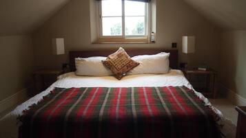 A bedroom with a bed, a window, two bedside tables, and a nightstand.