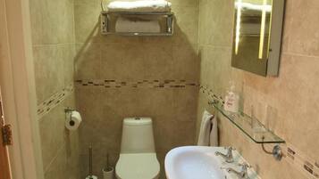 A small bathroom with a toilet, sink, and a towel rack.