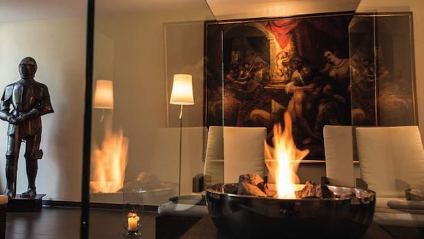 A modern lounge area with a fireplace, a statue, and a large painting on the wall. - Schloß-Hotel Petry (Treis-Karden)