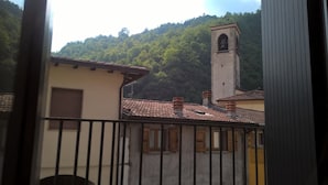 Un bâtiment doté d’un clocher, d’un toit en tuiles et offrant une vue sur une colline boisée.