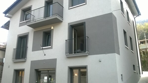 A multi-story building with balconies, windows, and a door. - La Casa Ritrovata (Marcheno)