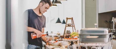 Eine moderne Küche mit einer Person, die Essen zubereitet, einem Grill und verschiedenen Lebensmitteln auf der Arbeitsfläche.