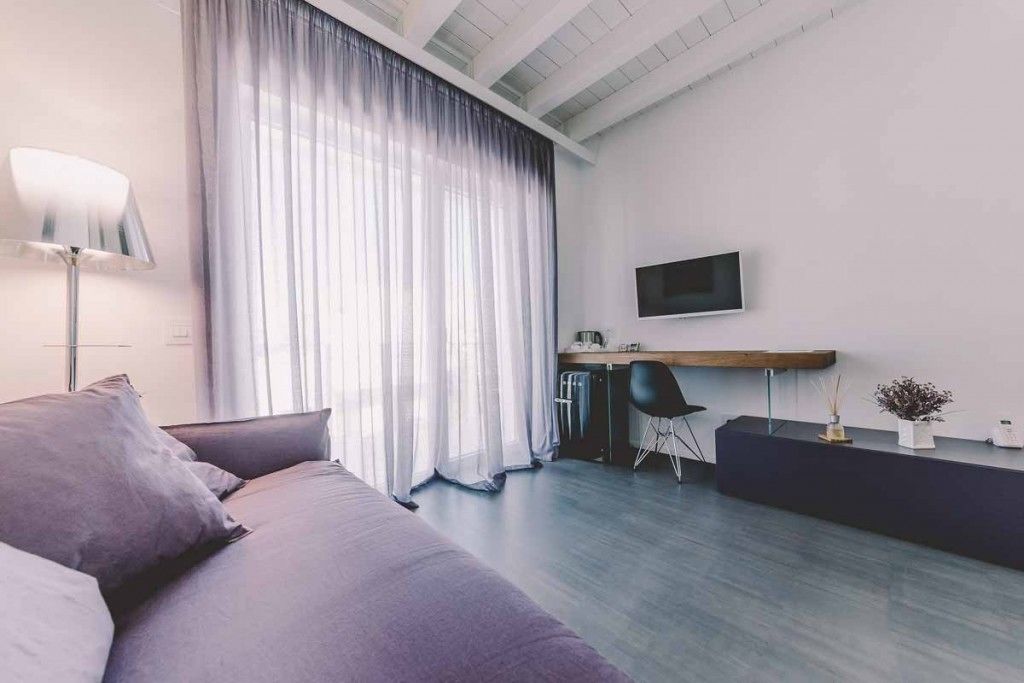 Un salon moderne avec un canapé, un bureau et un téléviseur.