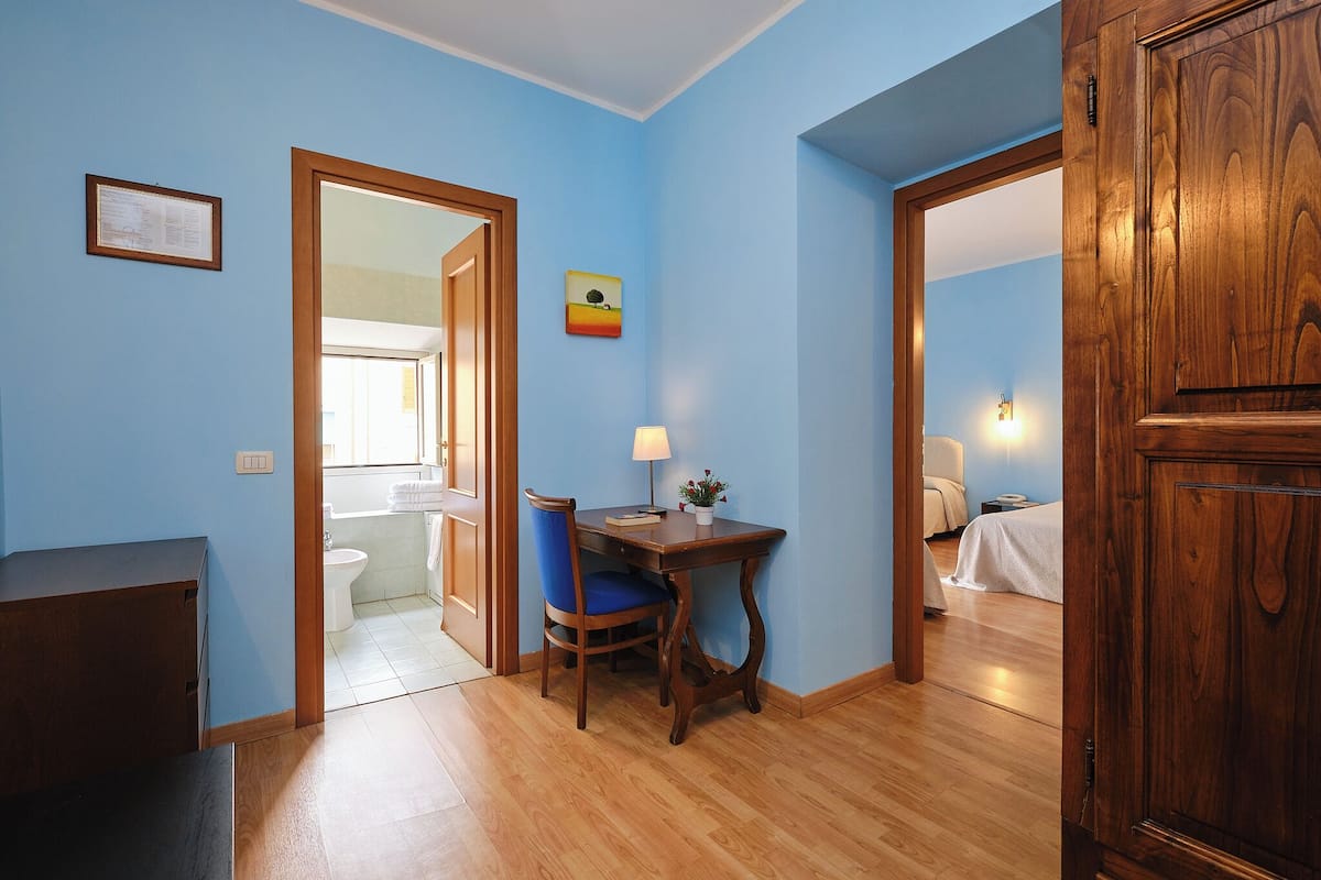 A room with a wooden table, blue walls, and a wooden cabinet.