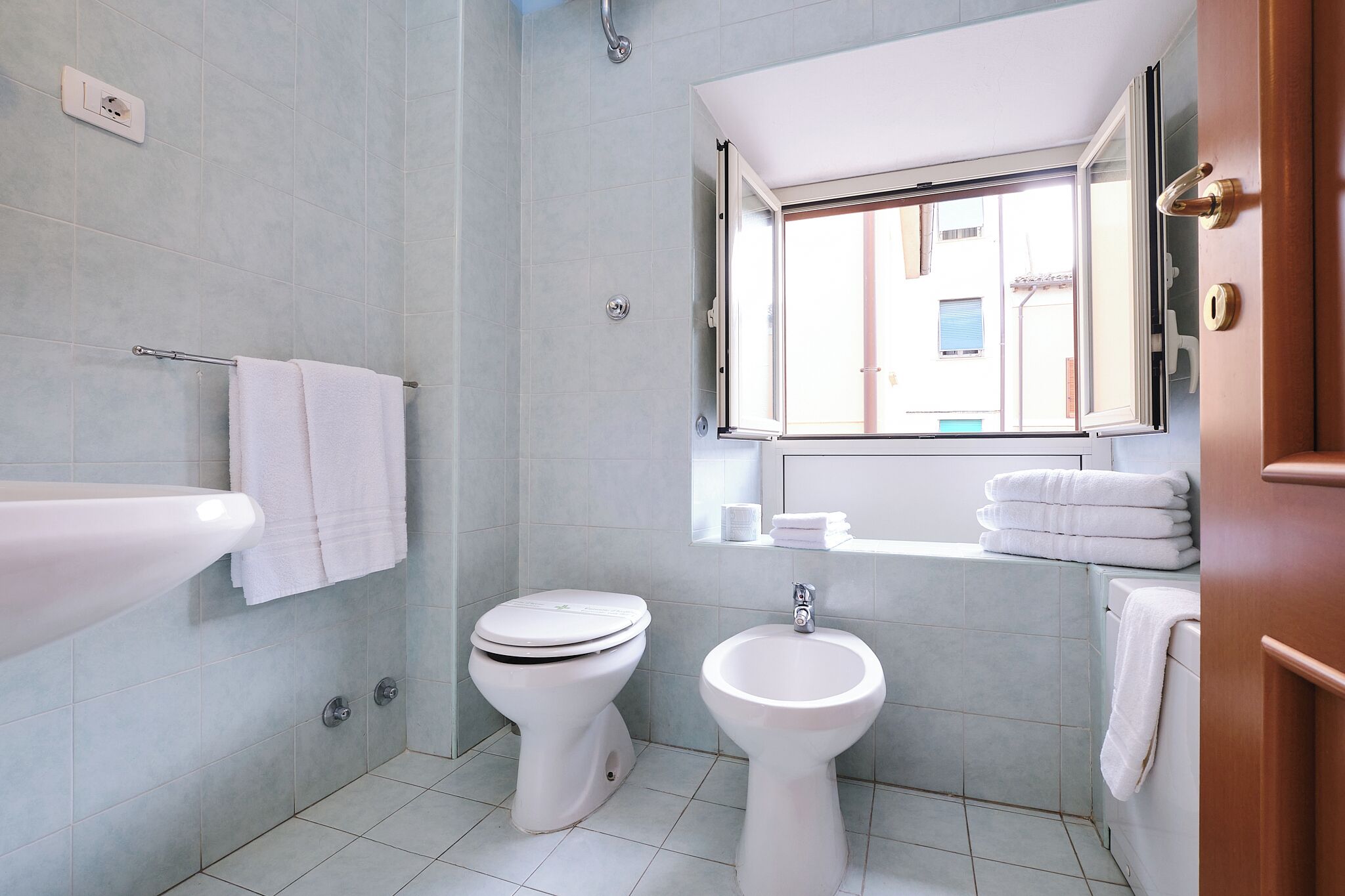 Un bagno moderno con WC, bidet e lavandino.