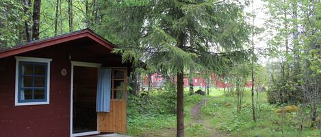 A small cabin with a wooden exterior, a single door, and a small porch.