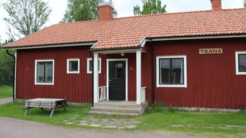 A red building with a tiled roof and a sign that reads "TRANA".