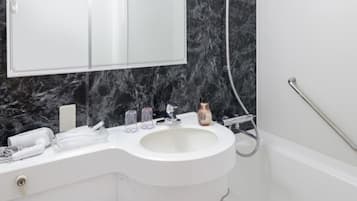 A bathroom with a white sink, a mirror above it, and a shower area.