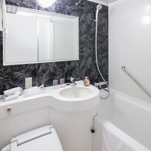 A bathroom with a white sink, a mirror above it, and a shower area. - HOTEL MYSTAYS Kagoshima Tenmonkan (Kagoshima)