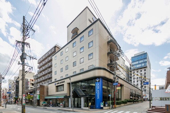 A hotel with a modern facade, multiple floors, and a prominent entrance with signage. - HOTEL MYSTAYS Kagoshima Tenmonkan (Kagoshima)