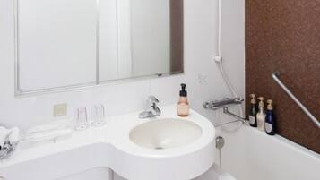 A bathroom with a white sink, a mirror, a shower, and a towel rack.