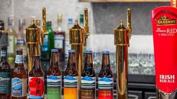 A bar with various bottles of beer and a red tap labeled "Irish Red Ale".