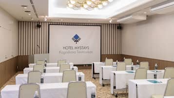 A conference room at Hotel Mystays in Kagoshima Tenmonkan with tables set up for meetings.