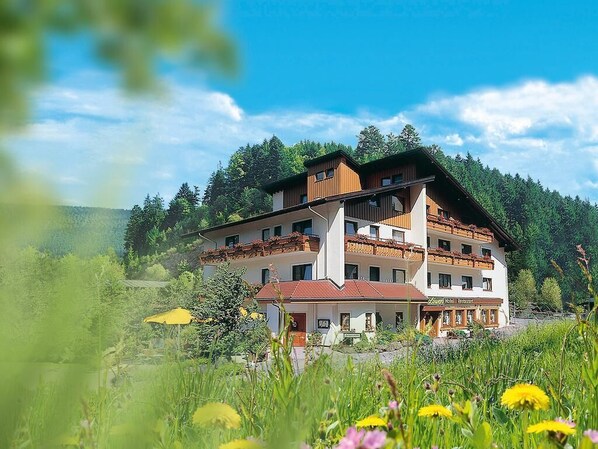 A multi-story hotel with a traditional architectural style, featuring balconies and a prominent entrance.
