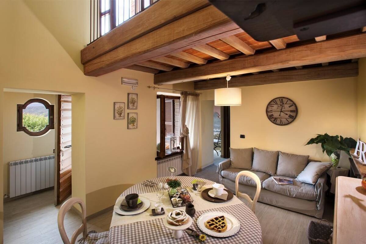 A dining area with a checkered tablecloth, a clock on the wall, and a plant on the table.