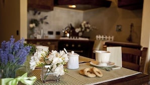 A dining table with a checkered tablecloth, a white teapot, cups, and cookies. - Agriturismo Ripaiani (Marsciano)
