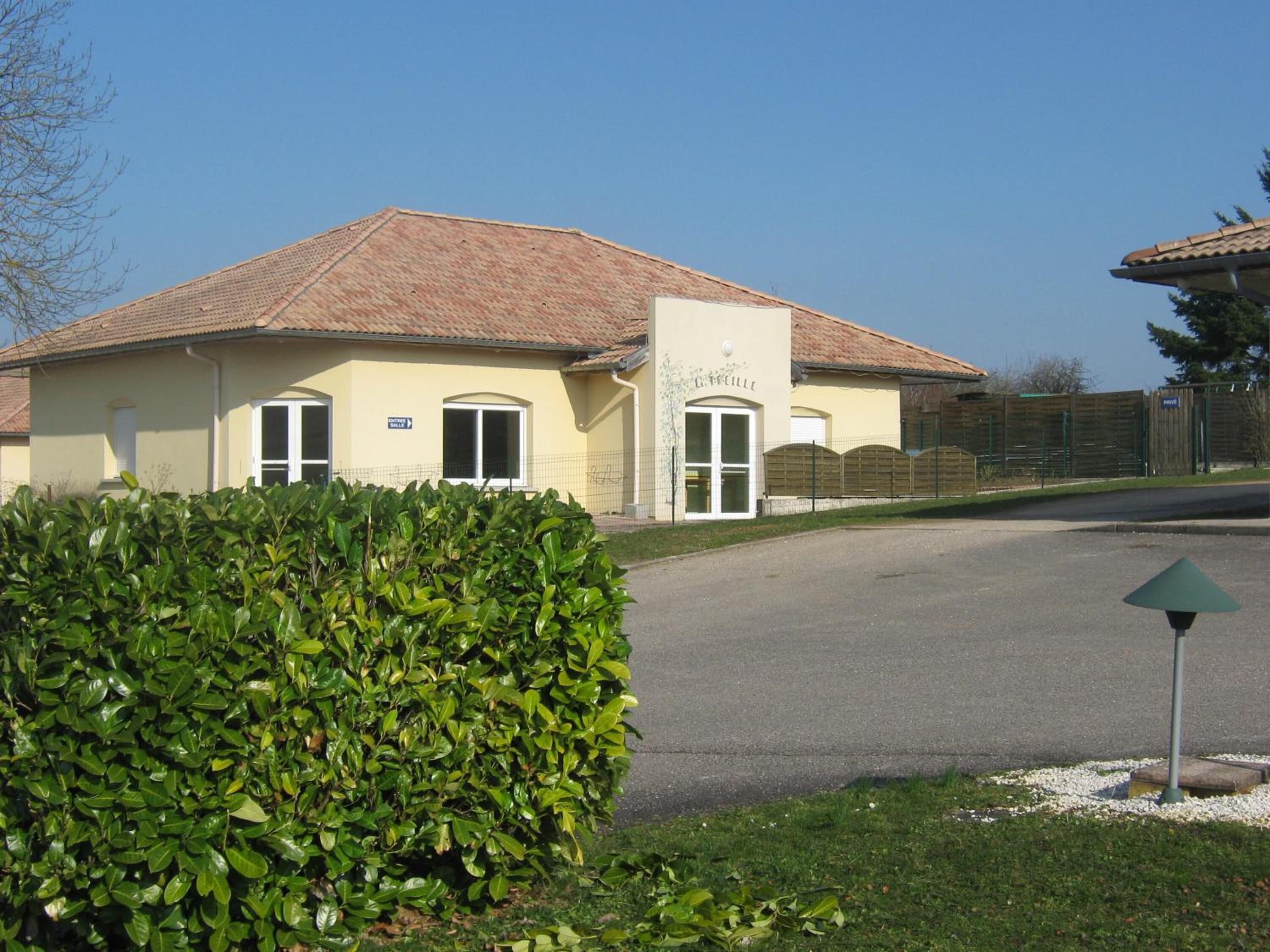 A building with a tiled roof, a sign reading "Café", and a paved entrance.