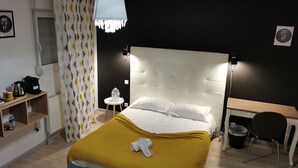 Un dormitorio ordenado con cama, mesita de noche y escritorio.