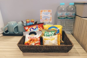 A snack basket with various packaged foods and two water bottles. - Tubtim Siam Suvarnabhumi Hotel (Bang Phli)