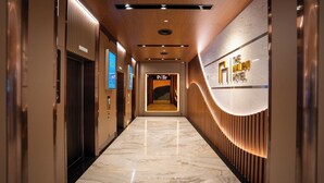 A hotel lobby with a marble floor, wooden paneling, and a reception desk. -  The Malibu Hotel (Ho Chi Minh City)