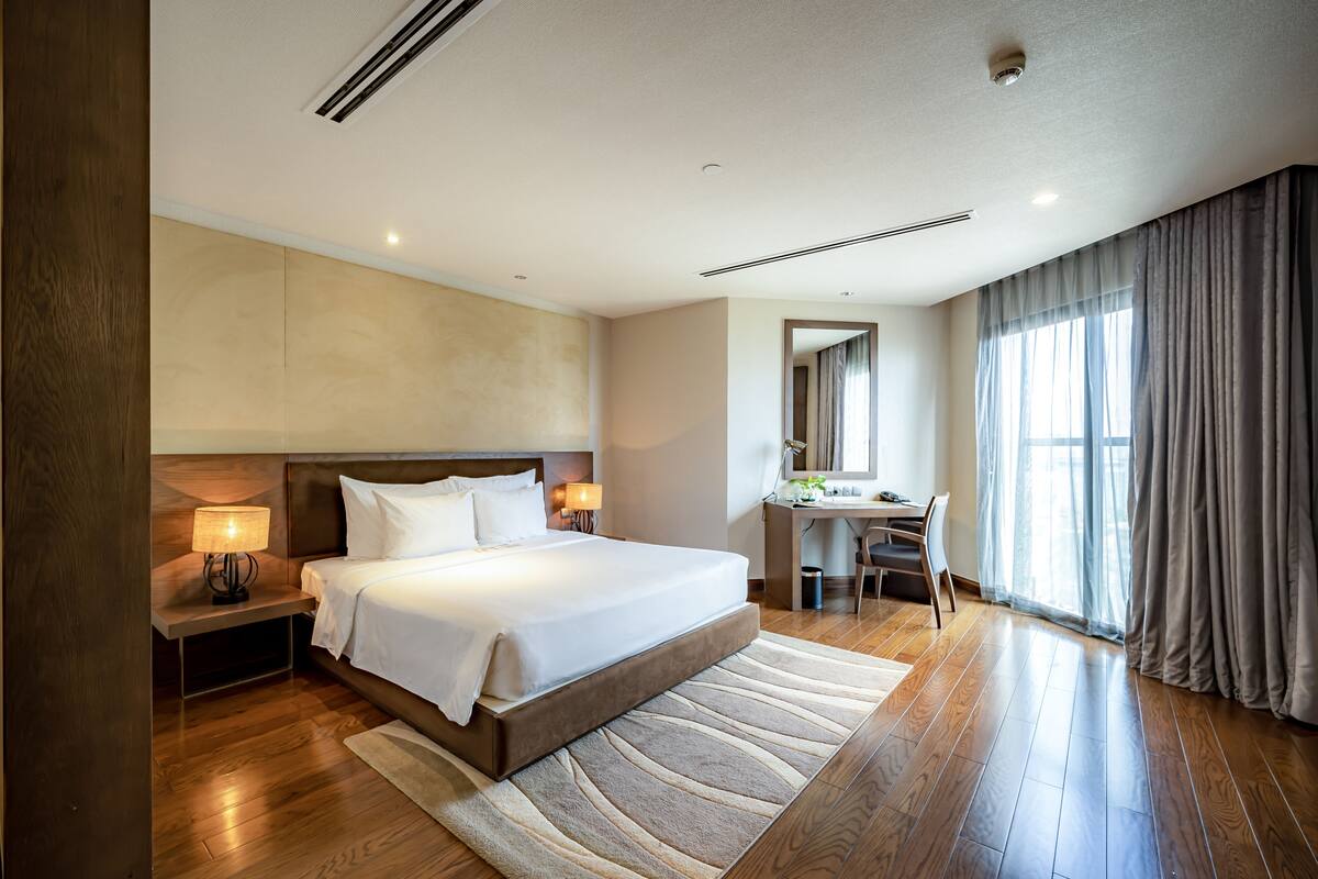 Ein Hotelzimmer mit einem großen Bett, einem Schreibtisch und einem Stuhl.
