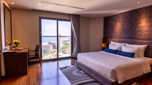 A hotel room with a large bed, a desk, and a view of the city. -  The Malibu Hotel (Ho Chi Minh City)