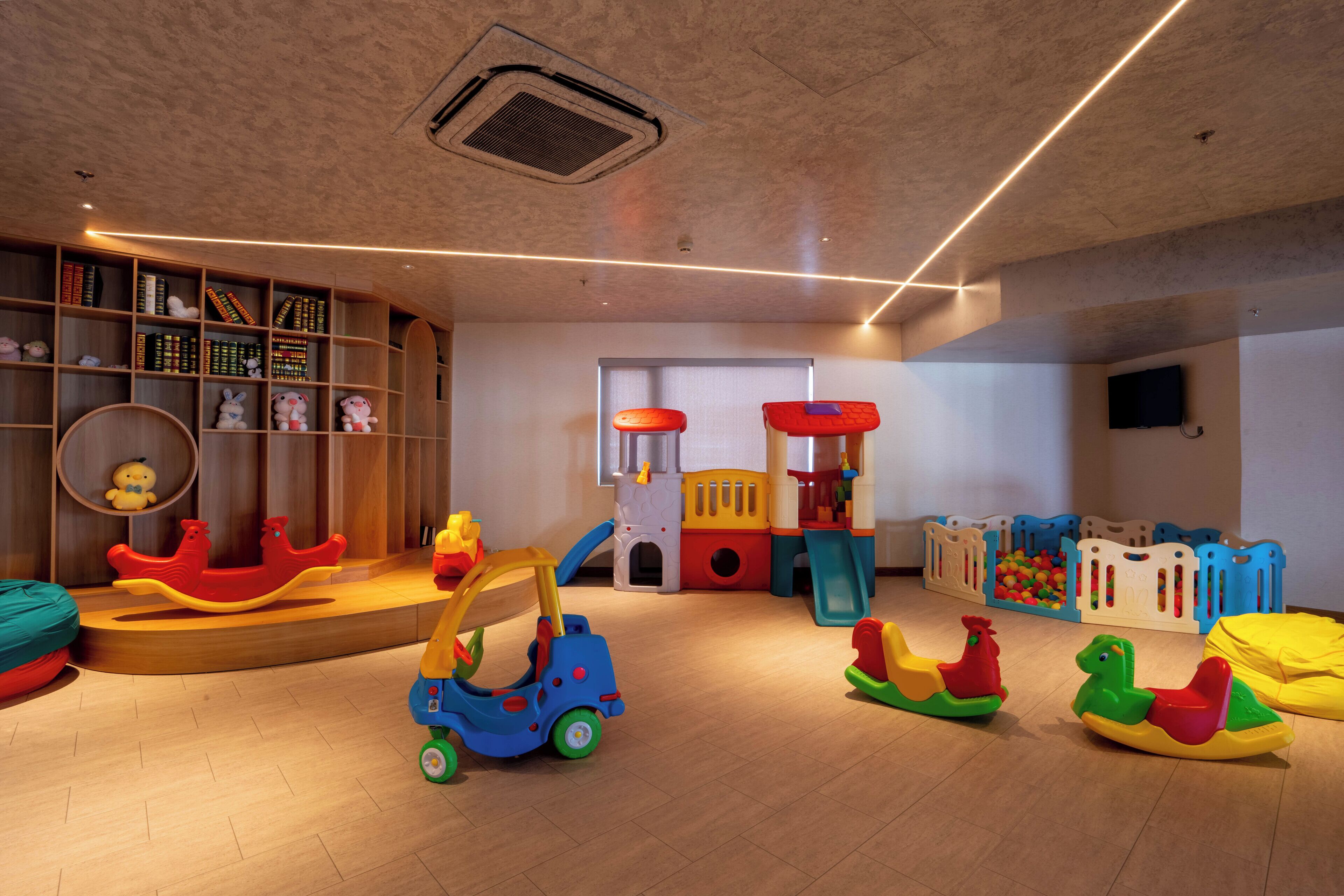 A children's play area with a slide, climbing structure, and various toys.