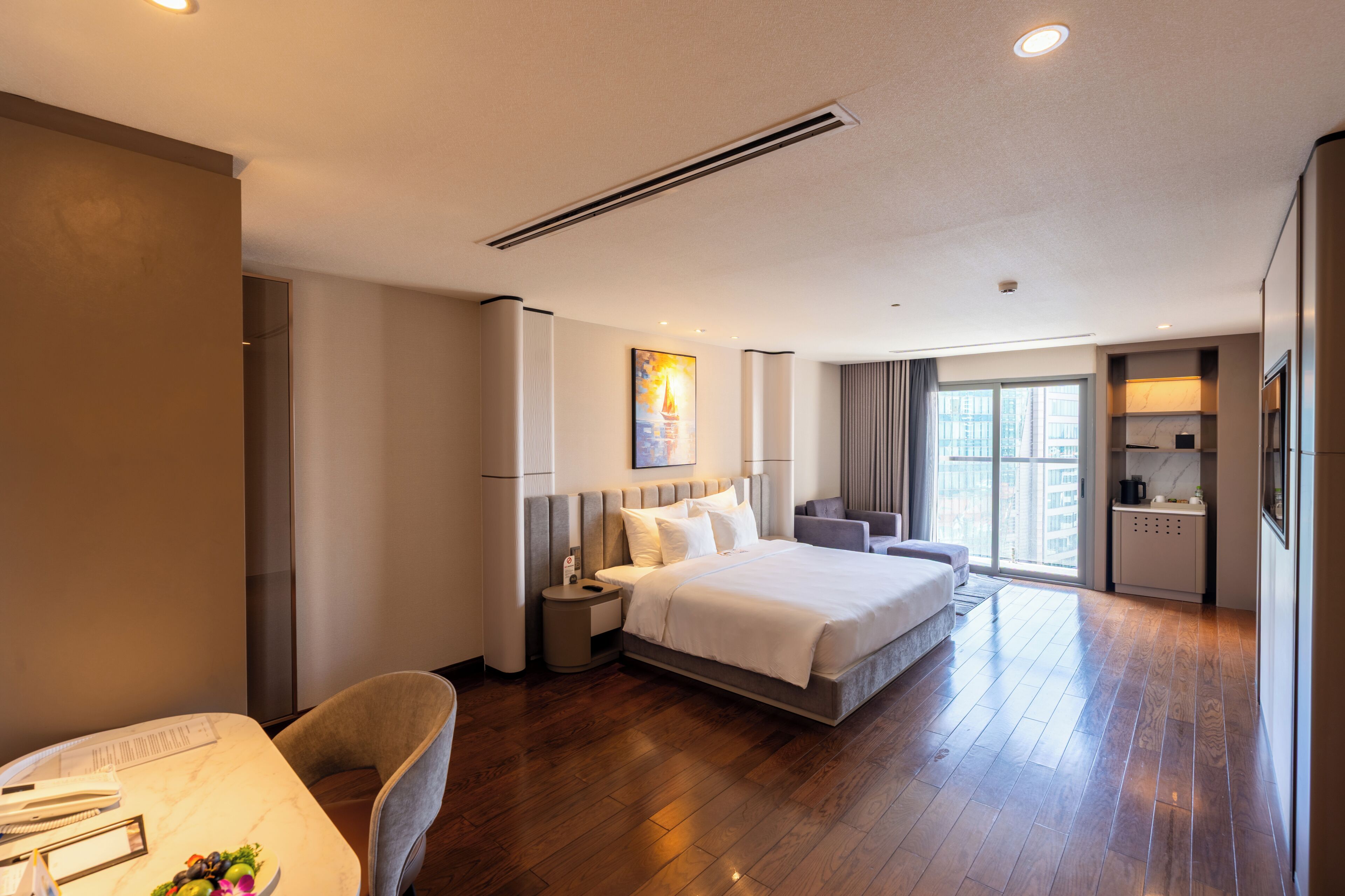Une chambre d’hôtel moderne, dotée d’un grand lit, d’un bureau et d’un coin repas.